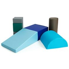 three different colored blocks sitting next to each other on a white surface and one is blue, the other is gray