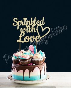 a birthday cake with cupcakes and sprinkled with love on top