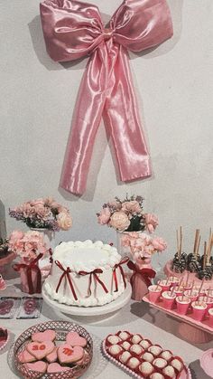 a table topped with lots of heart shaped cakes and cupcakes on top of plates