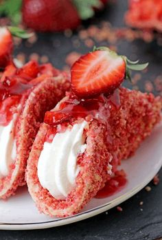 strawberry shortcakes on a plate with whipped cream and strawberries in the background