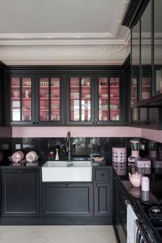 a black and white kitchen with pink accents