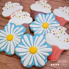 the cookies are decorated with blue and white frosting, daisies on top of them