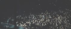 a large group of people standing on top of a stage in front of a crowd