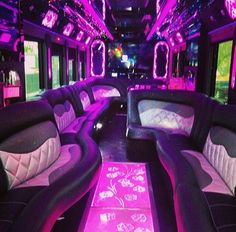 the inside of a party bus with purple and black leather seats, pink neon lights