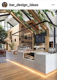 the interior of a restaurant with wooden floors and plants growing on the wall above it