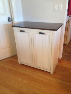 a white cabinet sitting on top of a hard wood floor