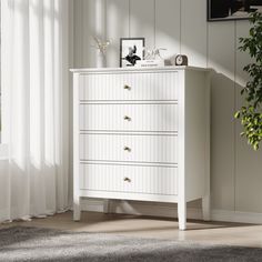 a white chest of drawers sitting next to a window