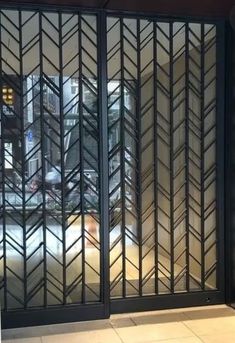 an image of a glass door that is in the middle of a street with buildings behind it