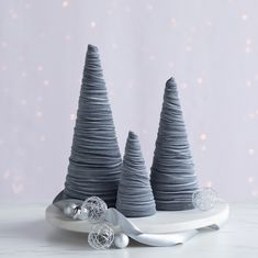 two grey christmas trees sitting on top of a white plate