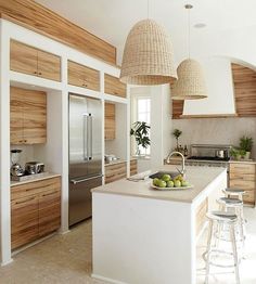 a kitchen with two hanging lights over the island