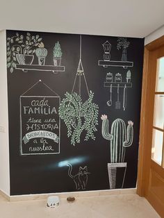 a chalkboard wall in a kitchen with potted cacti and succulents on it