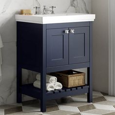 a bathroom vanity with a white sink and dark blue cabinet next to a toilet paper roll