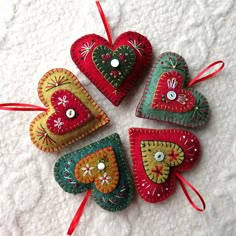 four heart shaped ornaments on a white surface