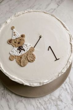 a white cake with a teddy bear on it