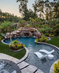 an outdoor swimming pool surrounded by landscaping