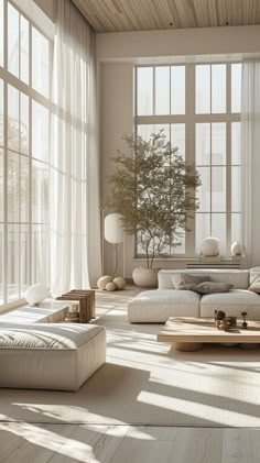 a living room filled with lots of white furniture and large windowed windows next to each other