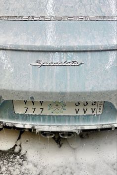 the front end of a car that is covered in snow