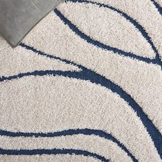 a blue and white area rug on the floor with a pillow in front of it