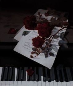 roses on top of sheet music and piano keys