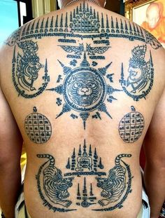 the back of a man with tattoos on his body