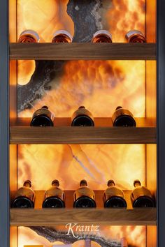 a display case filled with lots of bottles in front of a fireballing background