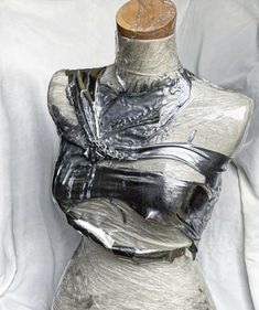 a mannequin is wrapped in silver foil