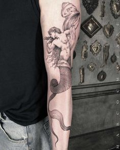 a man with a mermaid tattoo on his arm