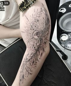 a woman's leg with a tattoo on it that has an eagle and feathers