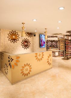 the inside of a jewelry store with gold and orange decorations on the wall, along with shelves