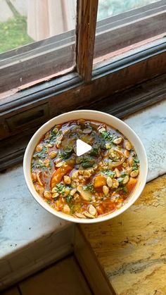 a bowl of food sitting on top of a window sill