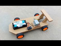 a skateboard made out of cardboard with an electronic device attached to the board and wheels