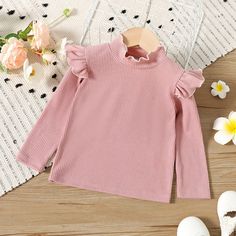 Update your toddler girl's wardrobe with this charming solid-color long-sleeve tee. Designed with a ruffled mock neck and ribbed details, this tee offers a stylish and adorable look. Made by PatPat, this tee is perfect for adding a touch of cuteness to your little one's outfit. Crafted with attention to detail, this tee features a ruffled mock neck that adds a feminine and fashionable touch. The ribbed details provide texture and depth to the design, making it stand out. Your toddler girl will l Girls Wardrobe, Toddler Tees, Mock Neck, Toddler Girl, Quality Fabric, Everyday Wear, Long Sleeve Tees, Solid Color, Texture