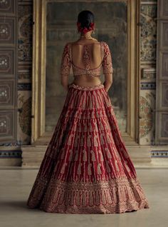 Make a bold statement in this deep red raw silk lehenga choli, featuring a net dupatta and worked belt. Embroidered in antique kasab with intricate appliqué work, it’s enhanced with dabka, sequins, beads, and crystals for a touch of luxury. Red Silk Lehenga With Sheer Dupatta, Elegant Red Raw Silk Choli, Red Silk Gown With Zari Work, Red Ceremonial Gown With Dupatta, Ceremonial Red Gown With Dupatta, Ceremonial Lehenga In Art Silk With Intricate Embroidery, Ceremonial Raw Silk Lehenga With Resham Embroidery, Indian Wedding Outfits Bridal Lehenga, Appliqué Work