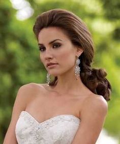 a beautiful woman in a wedding dress posing for the camera with her hand on her hip