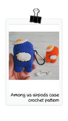 a hand holding a small crocheted object with the words among us arrows case