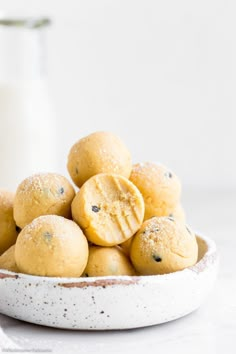 a white bowl filled with cookies next to a glass of milk