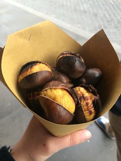 a person holding a box full of chestnuts