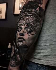 a man with a tattoo on his arm that has a woman's face in it