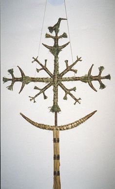 a cross made out of branches with birds on it