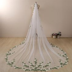 a white veil with green leaves on it