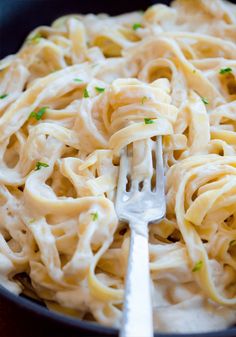 a fork is stuck into some noodles in a bowl