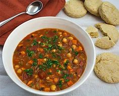 a white bowl filled with soup next to cookies