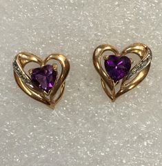 In these vintage earrings, Ken replaced the original heart shape stones with amethyst. The 14 K gold heart shape stud earrings also have very small diamonds. The overall earring size is 14 mm x 14mm. The dark amethyst gemstones are 6mm x 6mm. Amethyst is the birthstone for February. Heart-shaped Gemstone Earrings For Anniversary, Heart Shaped Gemstone Earrings For Anniversary, Anniversary Heart-shaped Gemstone Earrings, Formal Heart-shaped Birthstone Earrings, Vintage Double Heart Earrings For Anniversary, Gemstone Heart Earrings For Anniversary, Purple Anniversary Earrings, Gold Heart Earrings, Dark Amethyst