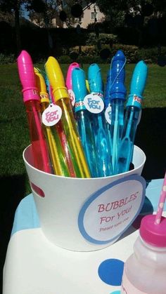 there are many pens in the cup on the table outside, and one is pink