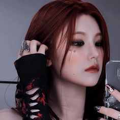 a woman with red hair holding a cell phone