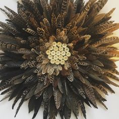 a clock made out of feathers on a wall