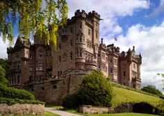 an old castle sitting on top of a lush green field