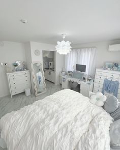 a large white bed sitting in a bedroom next to a window