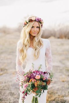 a woman with long blonde hair wearing a white dress and holding a bouquet