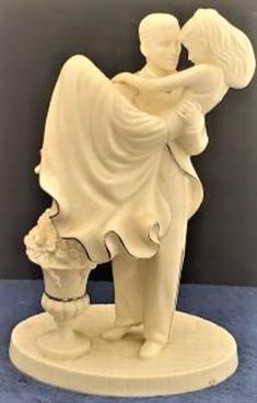 a white statue of a man holding a woman's head with her arms around him